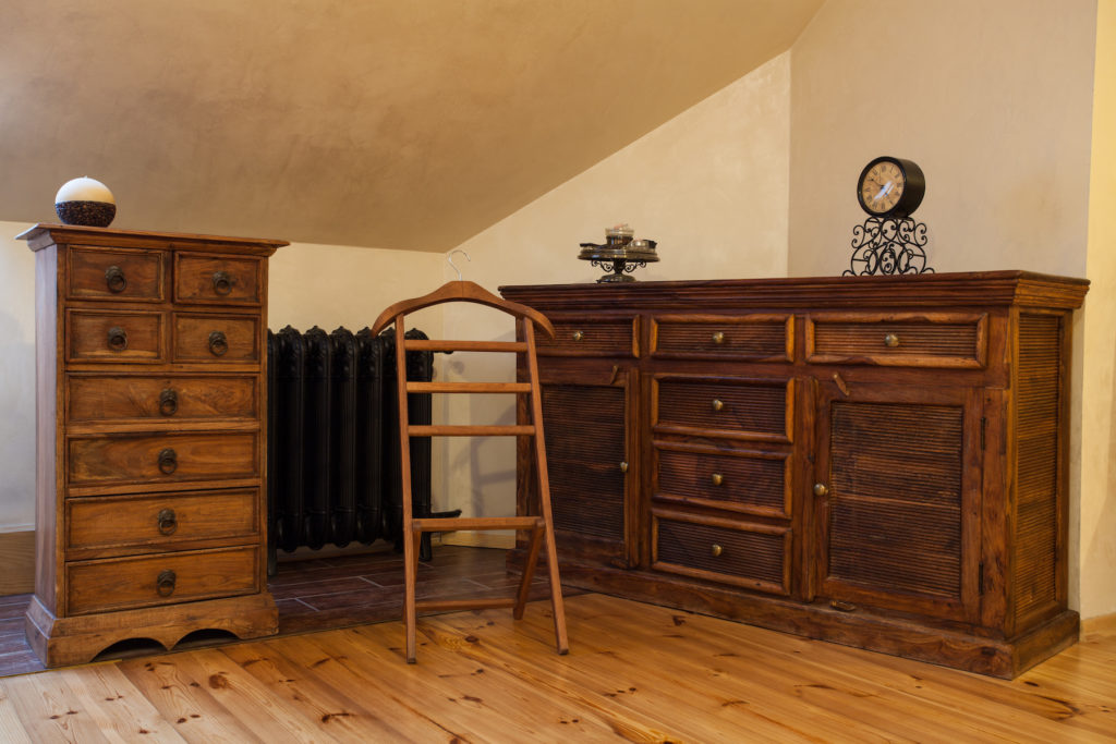 A bedroom with beautiful vintage furniture including an armoire and a dresser